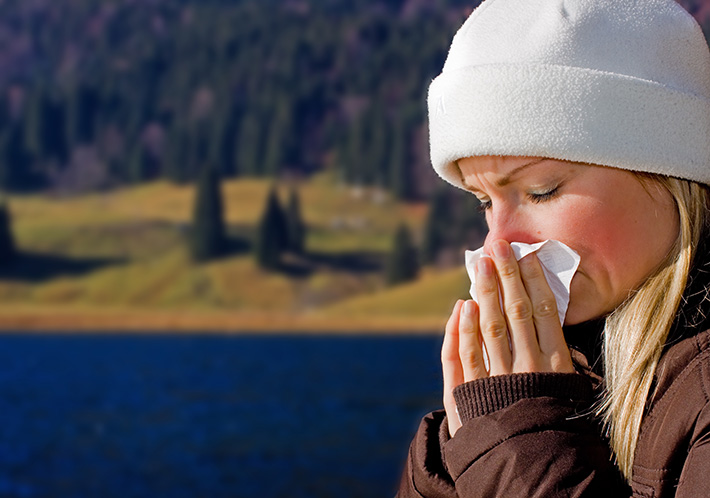 donna con il raffreddore che si soffia il naso